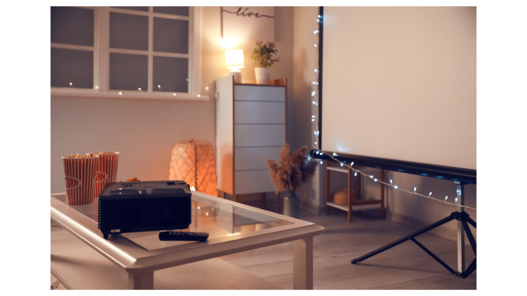 projector with popcorn and screen with fairy lights